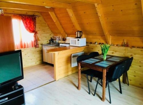 una habitación con mesa y una cocina en una cabaña en Domki w Rowach, en Rowy