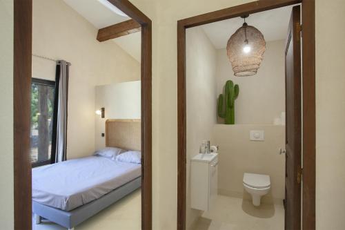 - une chambre avec un lit, des toilettes et un miroir dans l'établissement Villa Pianelli, à Sotta