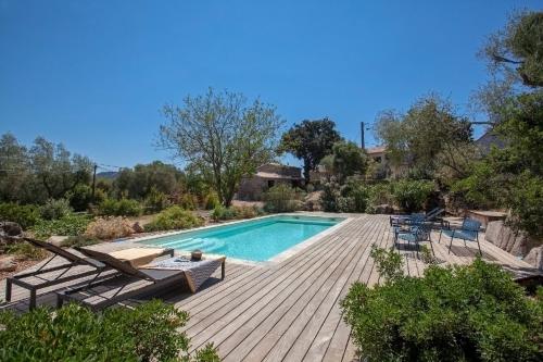 une piscine avec une terrasse en bois et une visière de piscine dans l'établissement Villa Pianelli, à Sotta