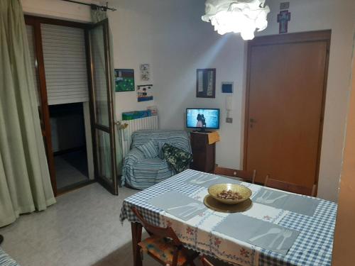 a living room with a table and a couch at Casa vacanza Colle Renazzo con terrazzo in collina 15 min. dal mare in Mafalda