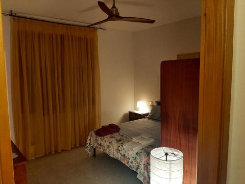 una camera con letto e ventilatore a soffitto di Casa vacanza Colle Renazzo con terrazzo in collina 15 min. dal mare a Mafalda