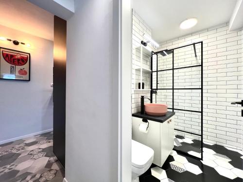 a bathroom with a white toilet and a shower at Castanilor 6 - Hip industrial apartment close to city centre in Braşov