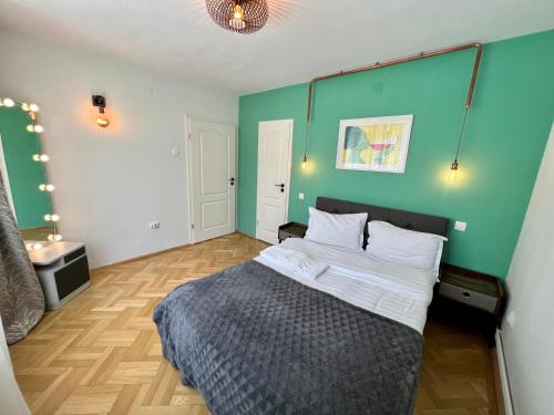 - une chambre avec un lit et un mur vert dans l'établissement Castanilor 6 - Hip industrial apartment close to city centre, à Braşov