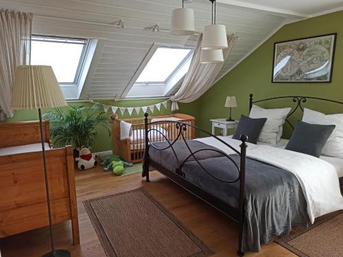 a bedroom with a large bed and two windows at by VOLLMER´s komfortabel und chic in Offenburg