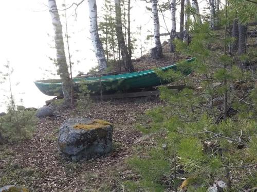 a green boat sitting on a hill in the woods at Mökki Salakka Rääkkylä Pohjois-Karjala in Nieminen