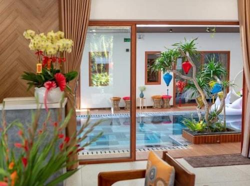 a living room with a swimming pool with plants and flowers at An Bang Sunset House in An Bang