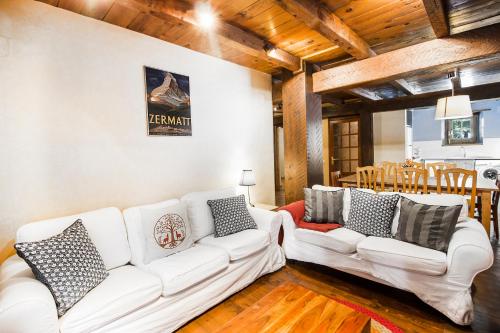a living room with two white couches and a table at Tarter Chalets Apartaments in El Tarter