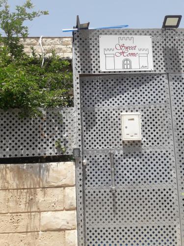 a metal fence with a sign on it at Sweet Little House in ‘Akko
