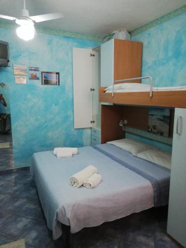a bedroom with a bunk bed with towels on it at Il Gabbiano blu - Monolocale Blu in Marettimo