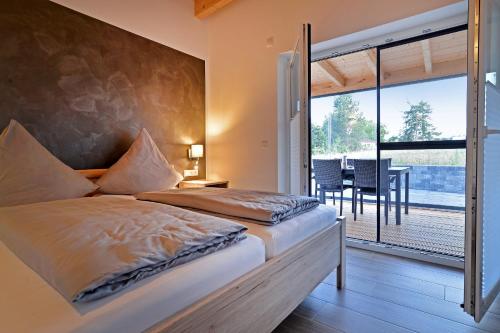 um quarto com uma cama grande e uma varanda em Ferienhäuser Brieden - "Haus Pommerbach" & "Haus Wegwarte" em Brieden