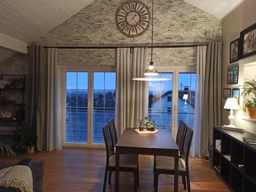 a dining room with a table and chairs and a clock at by VOLLMER´s komfortabel und chic in Offenburg