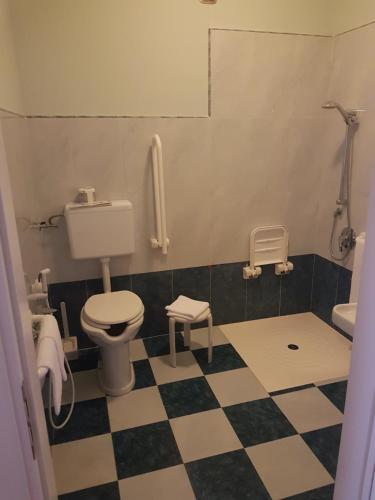 a bathroom with a toilet and a checkered floor at Semiramide Palace Hotel in Castellana Grotte