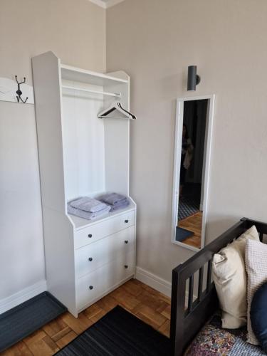 a bedroom with a white dresser and a mirror at Klimatyczny Apartament na Bydgoskim Przedmieściu in Toruń