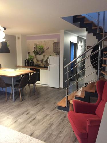 ein Wohnzimmer und ein Esszimmer mit einer Treppe und einem Tisch in der Unterkunft Apartament Nr.9 in Pobierowo