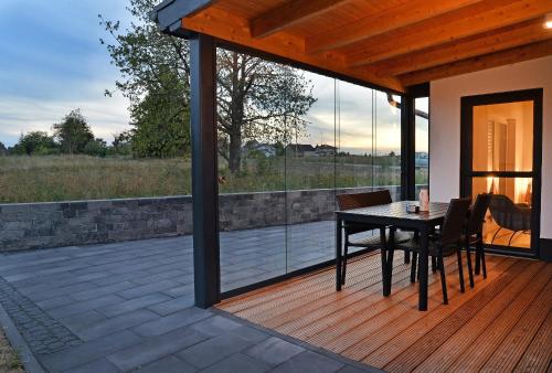 a patio with a table and chairs on a deck at Ferienhäuser Brieden - "Haus Pommerbach" & "Haus Wegwarte" in Brieden