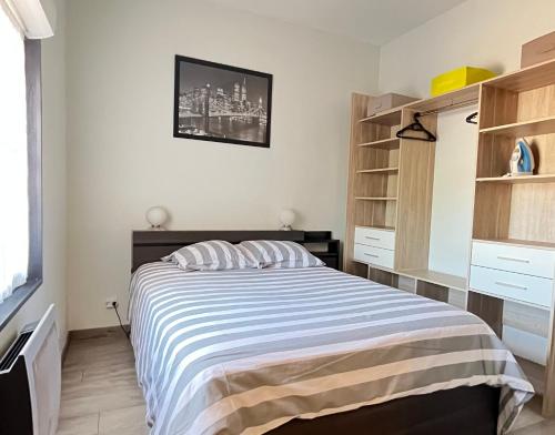 - une chambre avec un lit et une couverture rayée dans l'établissement Esprit libre, Beau 2 pièces climatisé, à Bordeaux