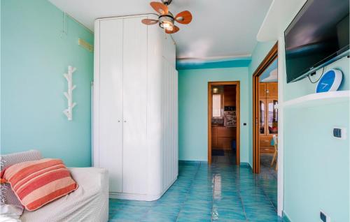 a living room with blue walls and a ceiling fan at Nice Home In Gaeta With Kitchen in Gaeta