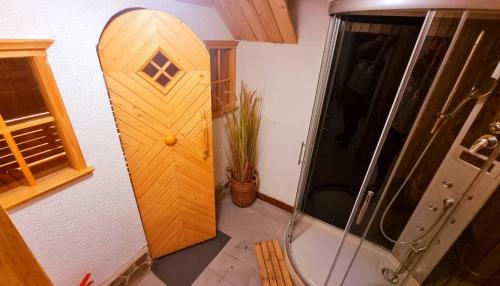 a bathroom with a shower and a surfboard on the wall at Hiška na samem in Mišji Dol