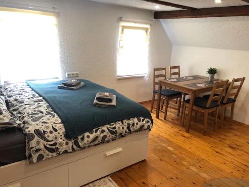 - une chambre avec un lit, une table et des chaises dans l'établissement SaidenbachHaus, à Großhartmannsdorf