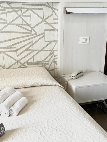 a bedroom with a bed with two towels on it at Hotel Villa Paola in Rimini