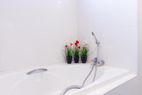a bathroom sink with two vases of flowers on a shelf at Kanchanaburi City Hotel in Kanchanaburi