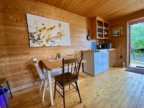 a kitchen and dining room with a table and a refrigerator at Haukland Camp Cabin in Leknes