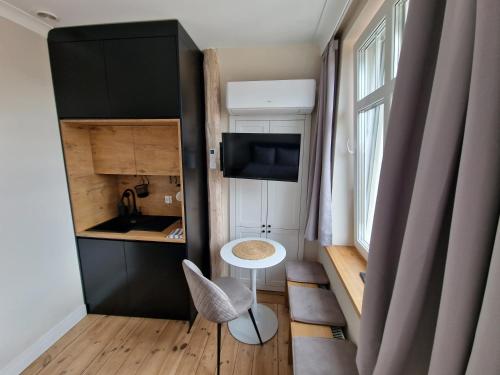 a small room with a table and a sink and a window at Klimatyczny Apartament na Bydgoskim Przedmieściu in Toruń