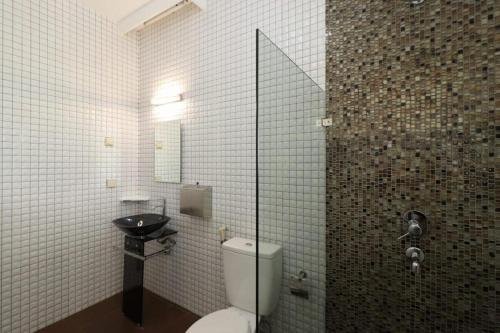 La salle de bains est pourvue de toilettes et d'un lavabo. dans l'établissement VILLA KELUARGA Syariah Resor Dago Pakar Bandung - View Bukit, à Bandung