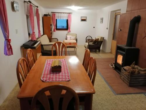 ein Esszimmer und ein Wohnzimmer mit einem Tisch und einem Herd in der Unterkunft Na samotě u lesa in Libňatov