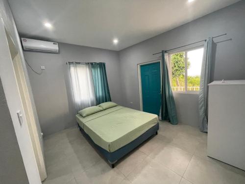 a bedroom with a bed in a room with a window at Hilltop Condos in Gros Islet