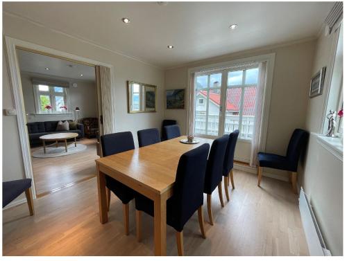 een eetkamer met een houten tafel en stoelen bij Måløy City Center - Château Kvalheim in Måløy