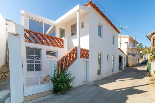 a white house with stairs on a street at Cellar House - Casa do Palheiro in Miranda do Corvo