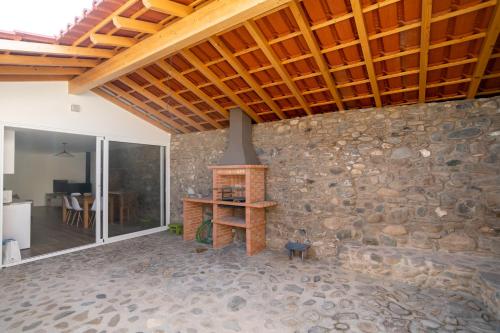a living room with a stone wall with a fireplace at Cellar House - Casa do Palheiro in Miranda do Corvo