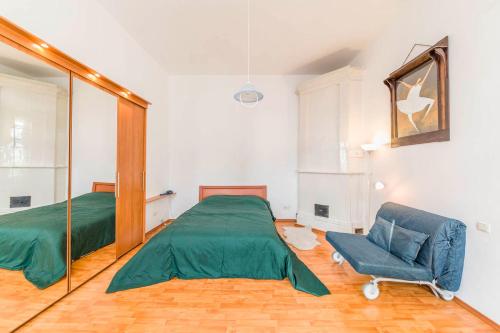 Un dormitorio con una cama verde y una silla en Feelathome Apartments on Millionnaya, en San Petersburgo
