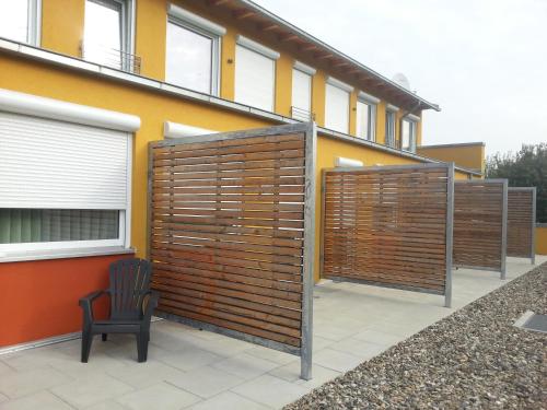 a building with wooden privacy fences on a patio at Hotel Quellenhof in Salzgitter