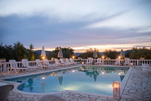 een zwembad met ligstoelen en een resort bij Villa Myrto in Pelekas