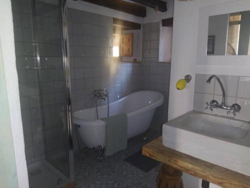 L’ EsquirolにあるLa caseta de El Llancísのバスルーム(バスタブ、シャワー、シンク付)