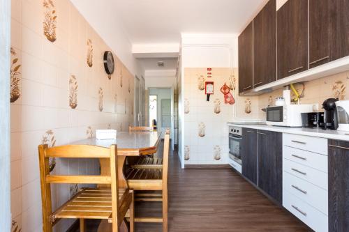 a kitchen with wooden cabinets and a table and chairs at Casa do Faria in Caminha