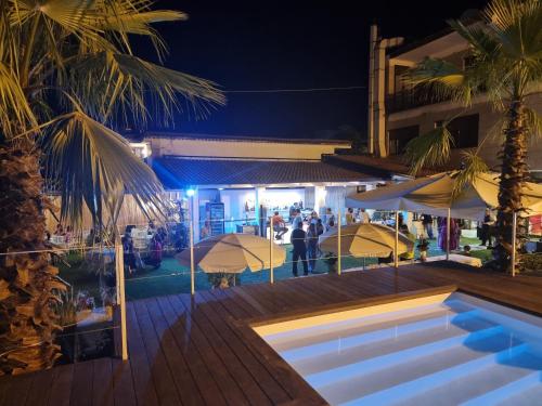 a pool with umbrellas and a restaurant at night at Ranch Palace Hotel in Naples