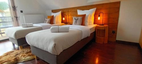 um quarto com 2 camas com edredões brancos em Domki Cztery Pory Roku em Lapsze Niżne