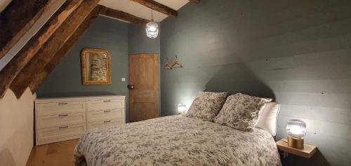 a bedroom with a bed with two lamps and a dresser at Maison typique des monts du Cantal in Marmanhac