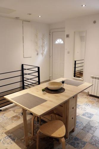 une cuisine avec une table en bois et deux chaises dans l'établissement Maison 2 chambres 100m du Théâtre Antique avec salle cinéma, à Orange