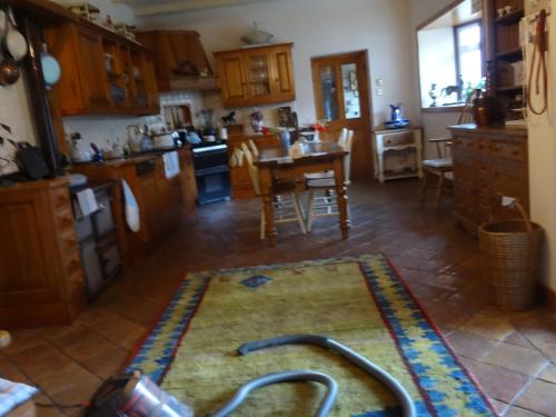 a kitchen with a rug on the floor and a table at Cleriach Cottage in Milton of Auchinhove
