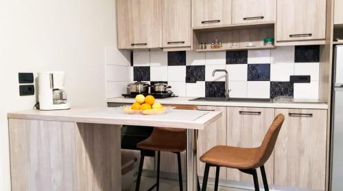 a kitchen with a counter with chairs and a plate of fruit at Yucca Studio, beautiful apartment with garden in Ropanianá
