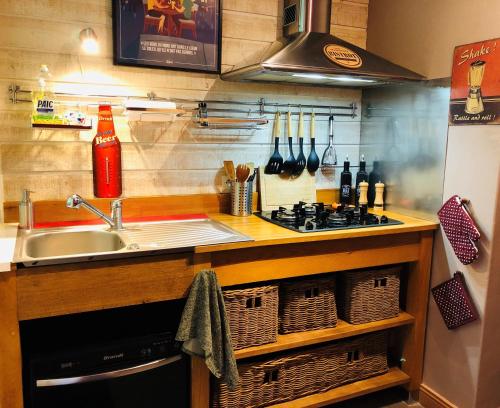 a kitchen with a sink and a stove and baskets at "BELLEVUE" Magnifique appartement vue sur mer et face à Nausicàa in Boulogne-sur-Mer