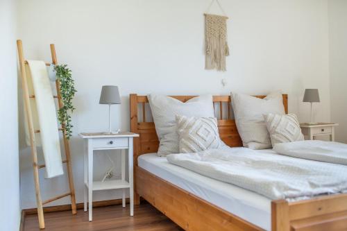 een slaapkamer met een bed met witte lakens en kussens bij Ferienwohnung Landparadies im Sauerland in Bestwig