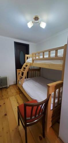 a bedroom with two bunk beds and a chair at House in Gergeti in Kazbegi