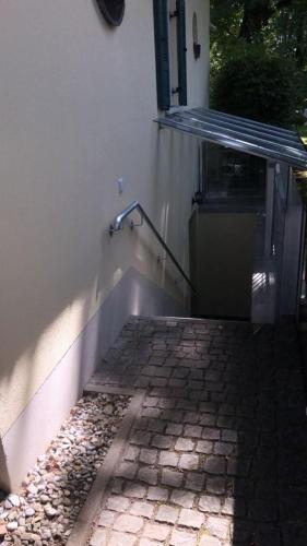 a brick walkway with a railing next to a building at Ferienwohnung Villa Tana Miesbach in Miesbach