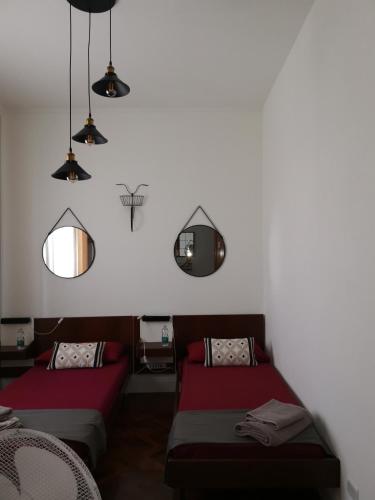 a room with two beds and a tv on the wall at Villa Flora Affittacamere in Luni