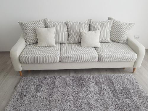 a couch with two pillows on it in a living room at Alexa Apartament in Târgu-Mureş